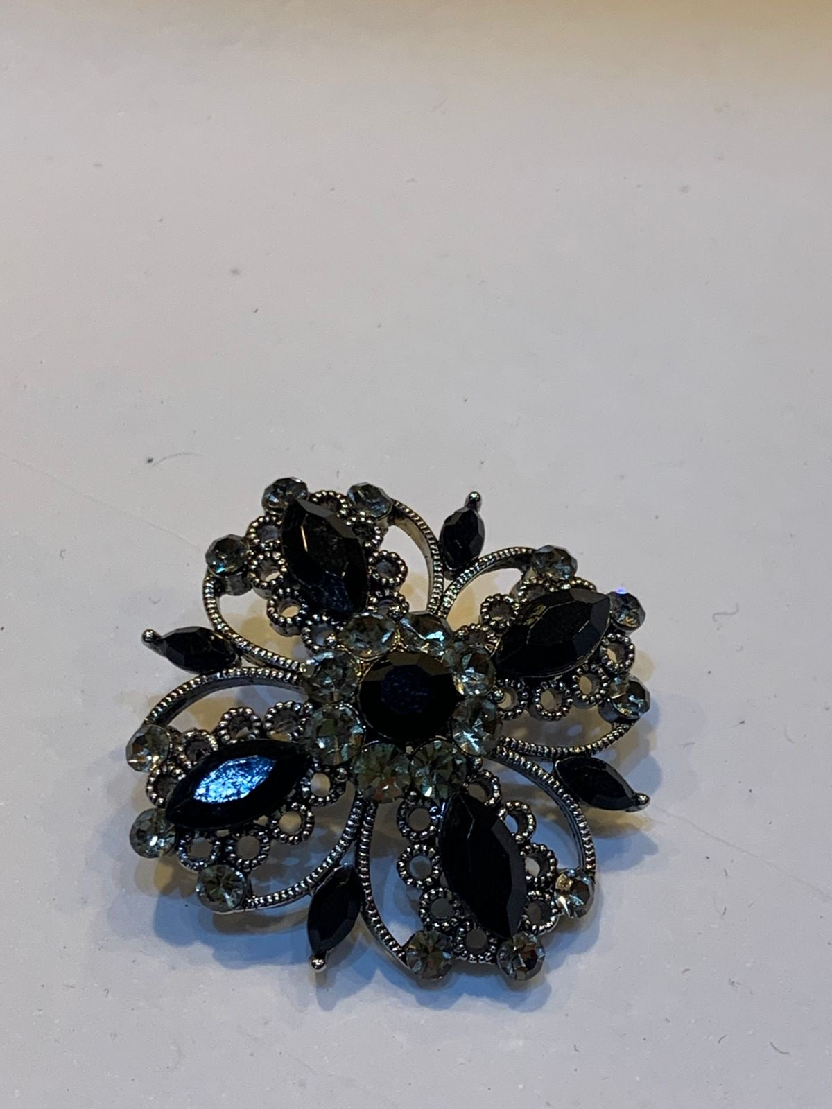 Broche flor cravejado pedras pretas