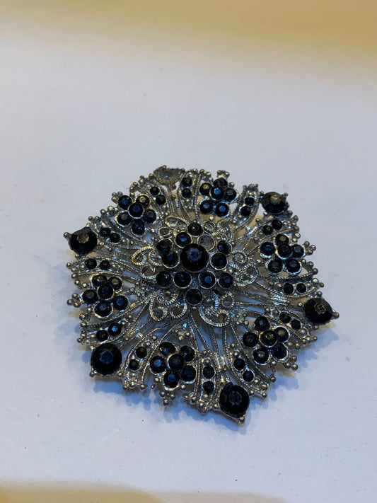 Broche cravejado dourado e preto
