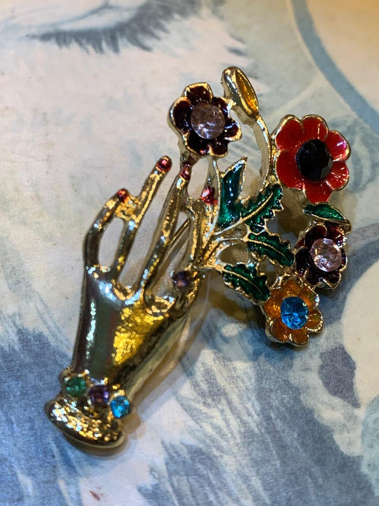 Broche esmaltado em formato de mão e flores