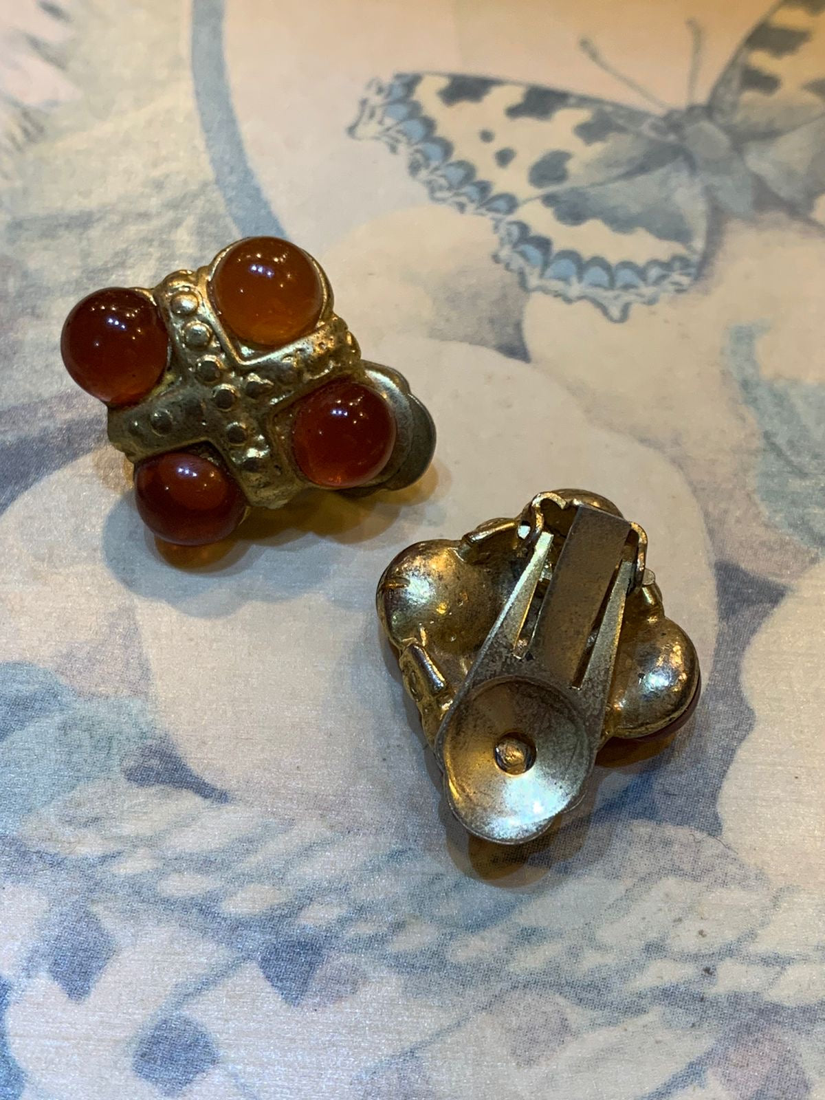 Brinco de pressão dourado com quatro pedras vermelhas